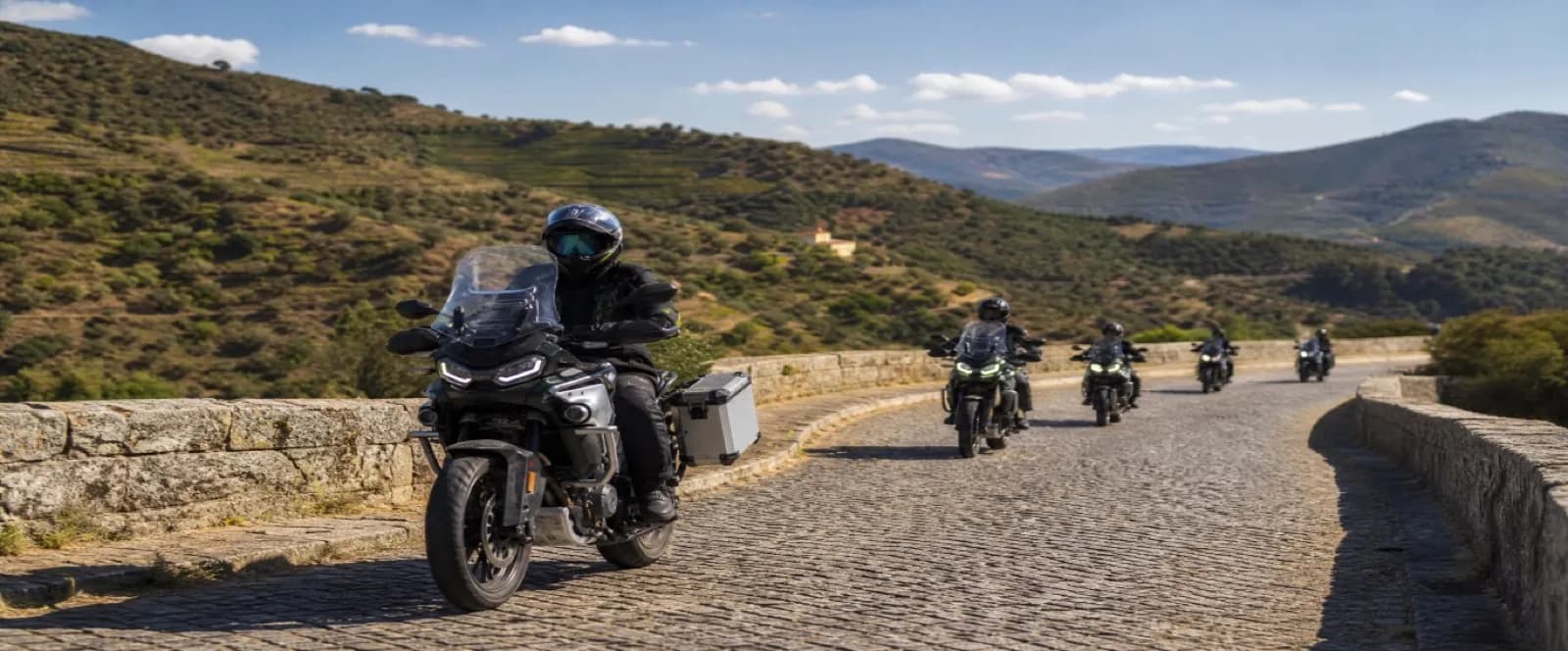 Motociclistas em estrada de paralelepípedo em Portugal